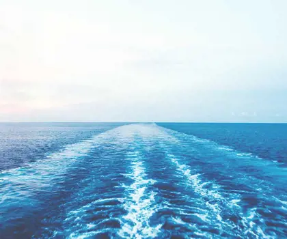 image of the ocean wih waves created from a ship seen from the back of the ship